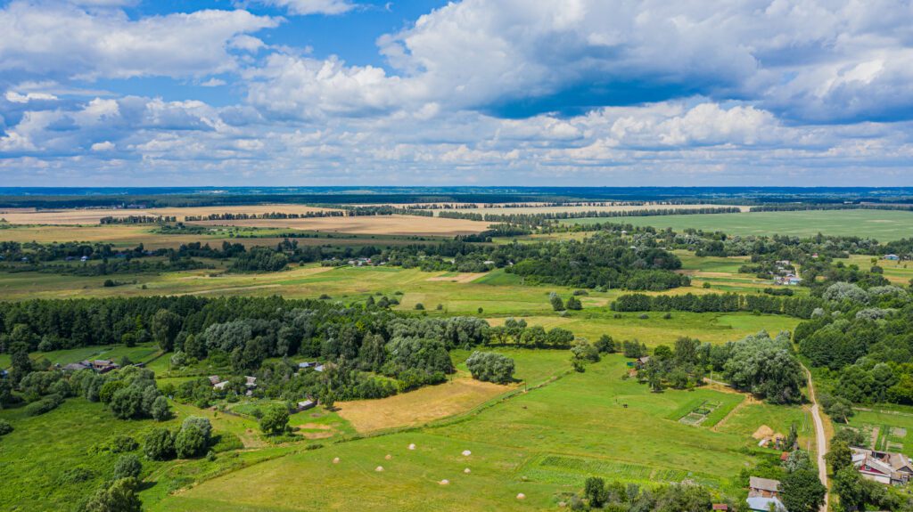 Aerial view over beautiful suburb in wide valley, in the summer. Top view to the small village with a beautiful green landscape.