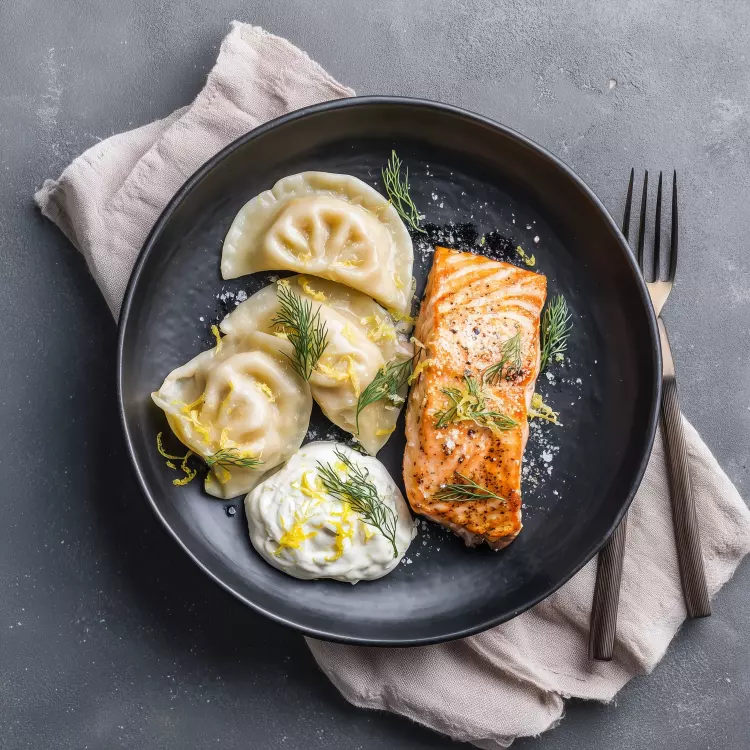 2 pavés de saumon grillés, crème sûre citronnée à l'aneth, pierogis de pommes de terre