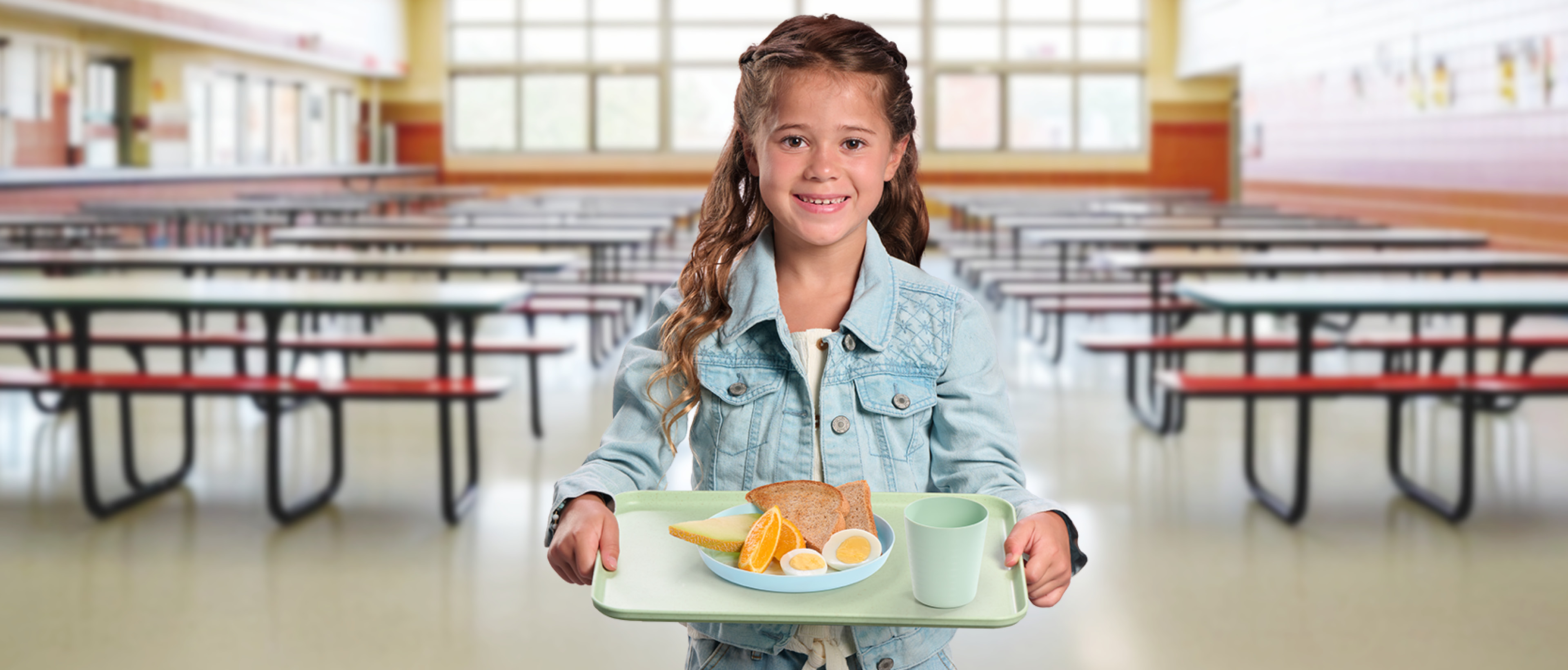 Jeune enfant heureuse avec son plateau déjeuner complet