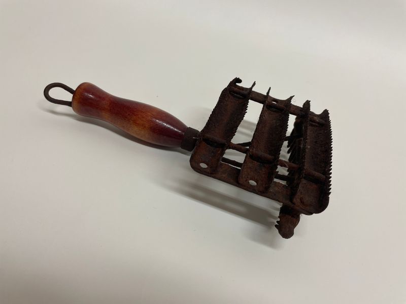 Étrille, XXe siècle-Métal; bois-23 cm x 5 cm-Musée acadien de l’Université de Moncton-1969-21-103