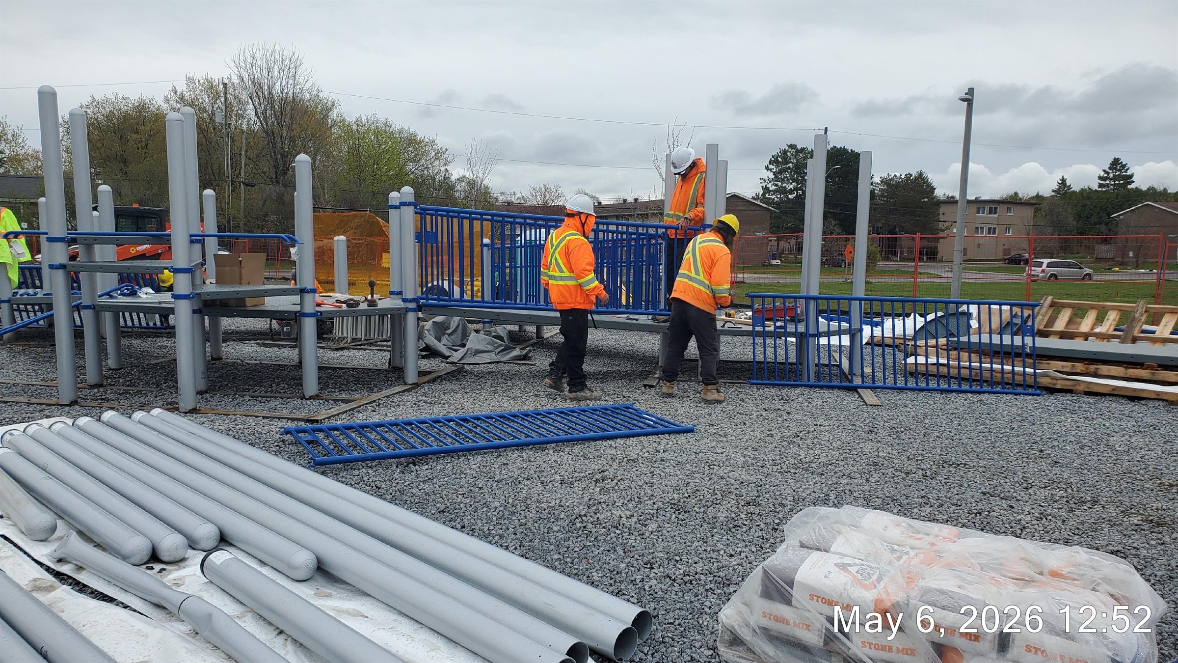 Construction workers installing a railing on a new playground