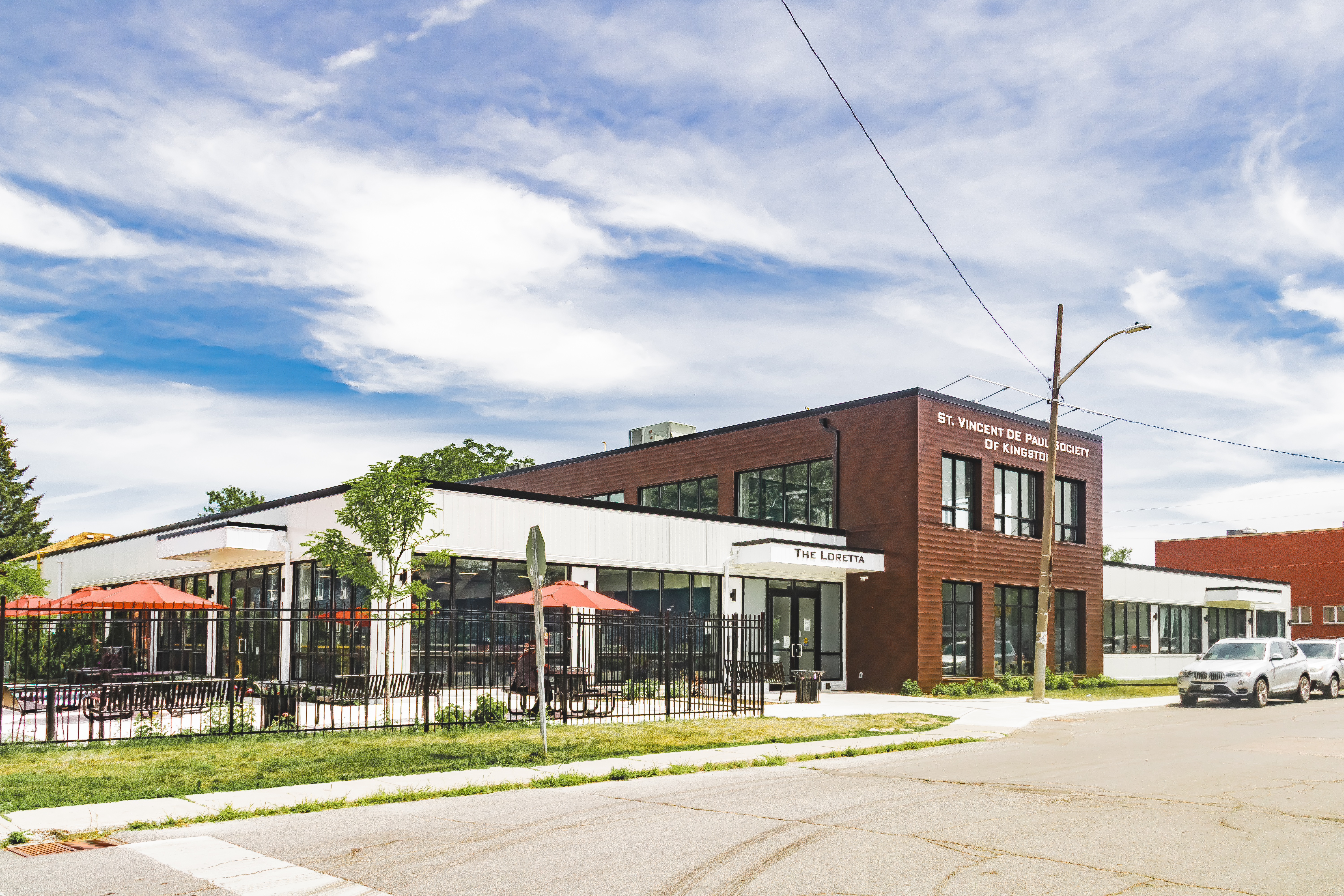 The St. Vincent de Paul Society facade. One half of the building is white concrete, the other half is red brick. 