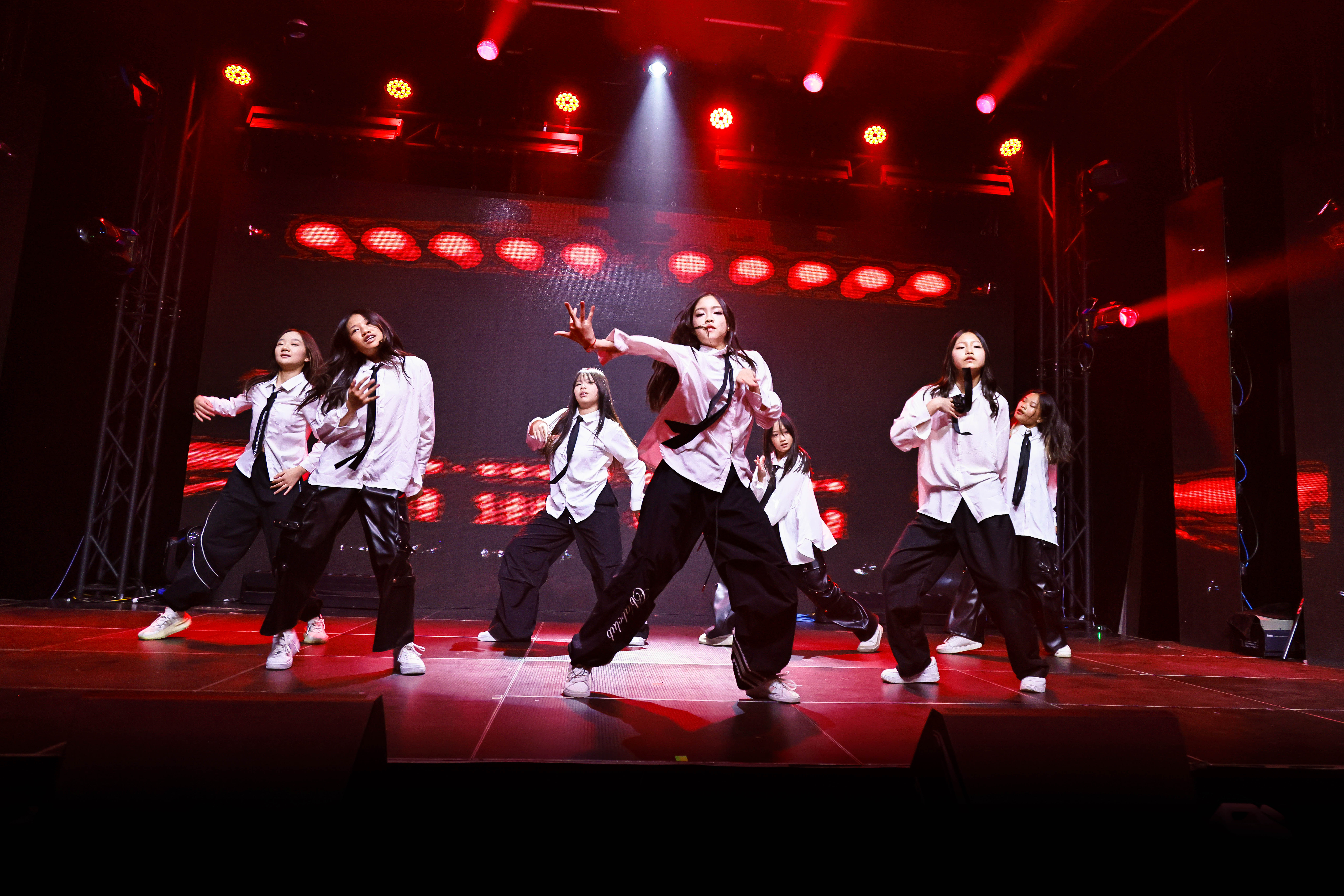 Dance group performing Sweet Venom dance on stage.