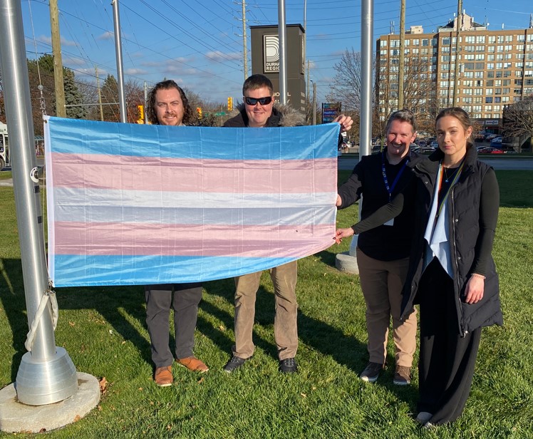 Members of the 2SLGBTQI+ Committee holding the Transgender flag