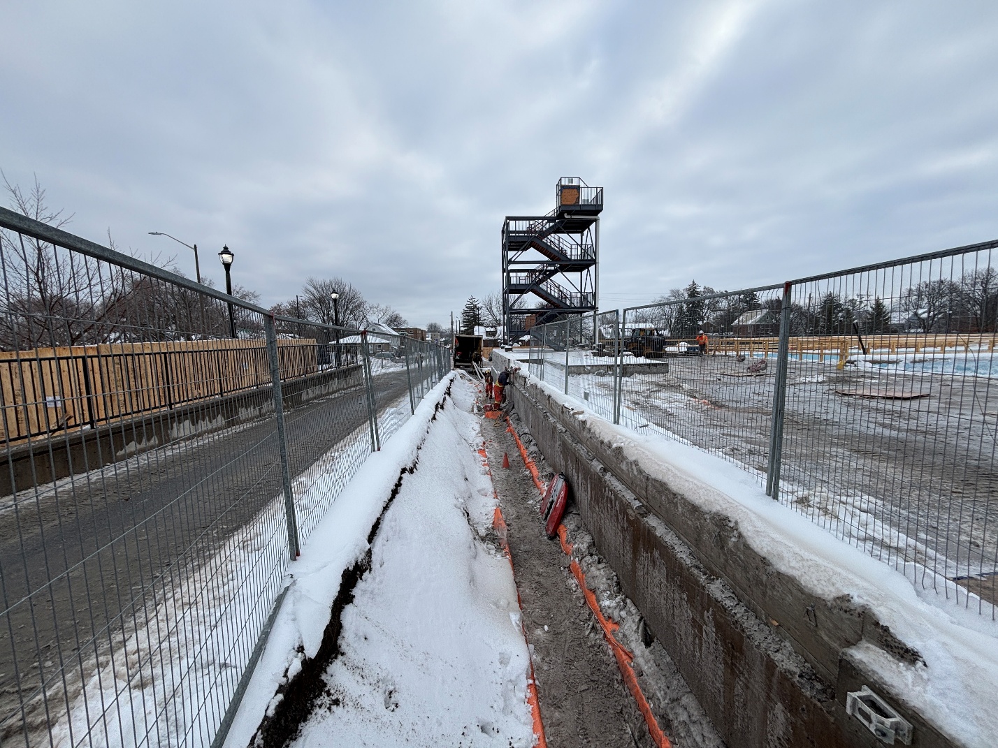 Image from West along North perimeter wall. General excavation and masonry cladding removals completed. Fencing along foundation excavation in place.