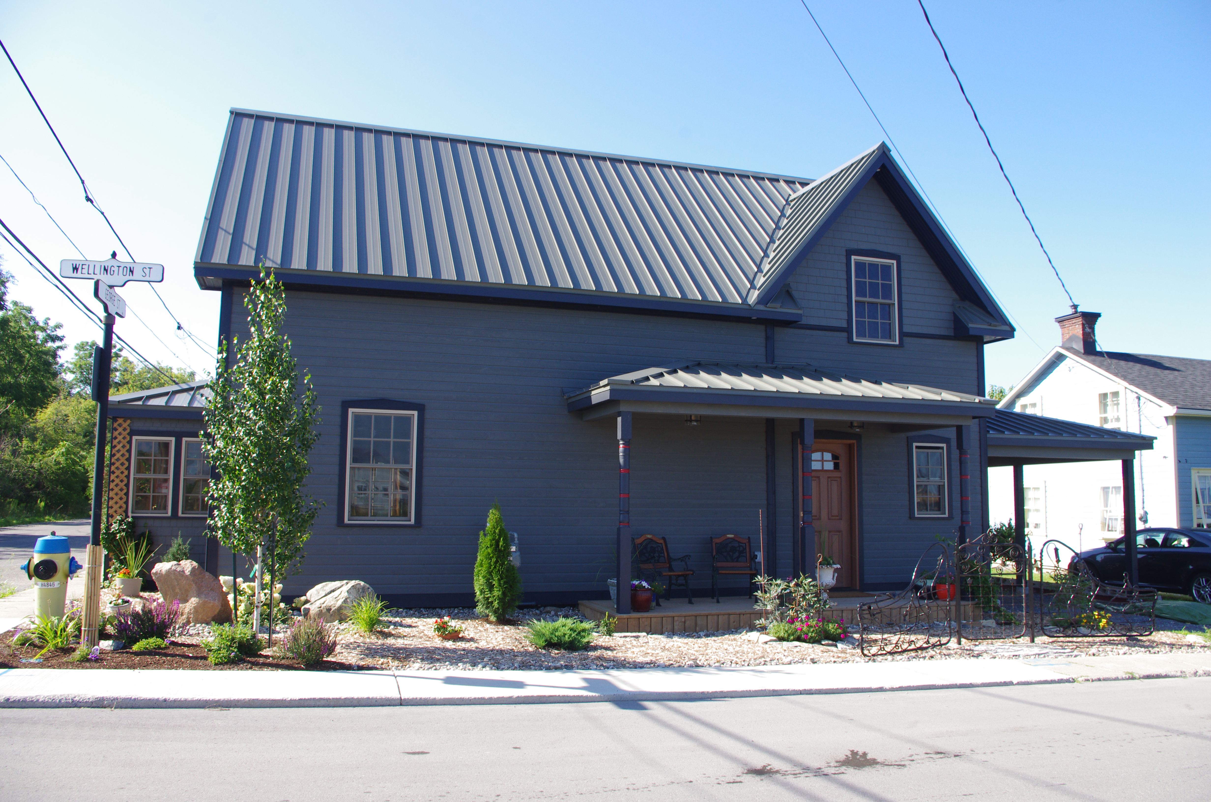 A renovated home on 9 George St. with slate gray siding and a metal roof. 