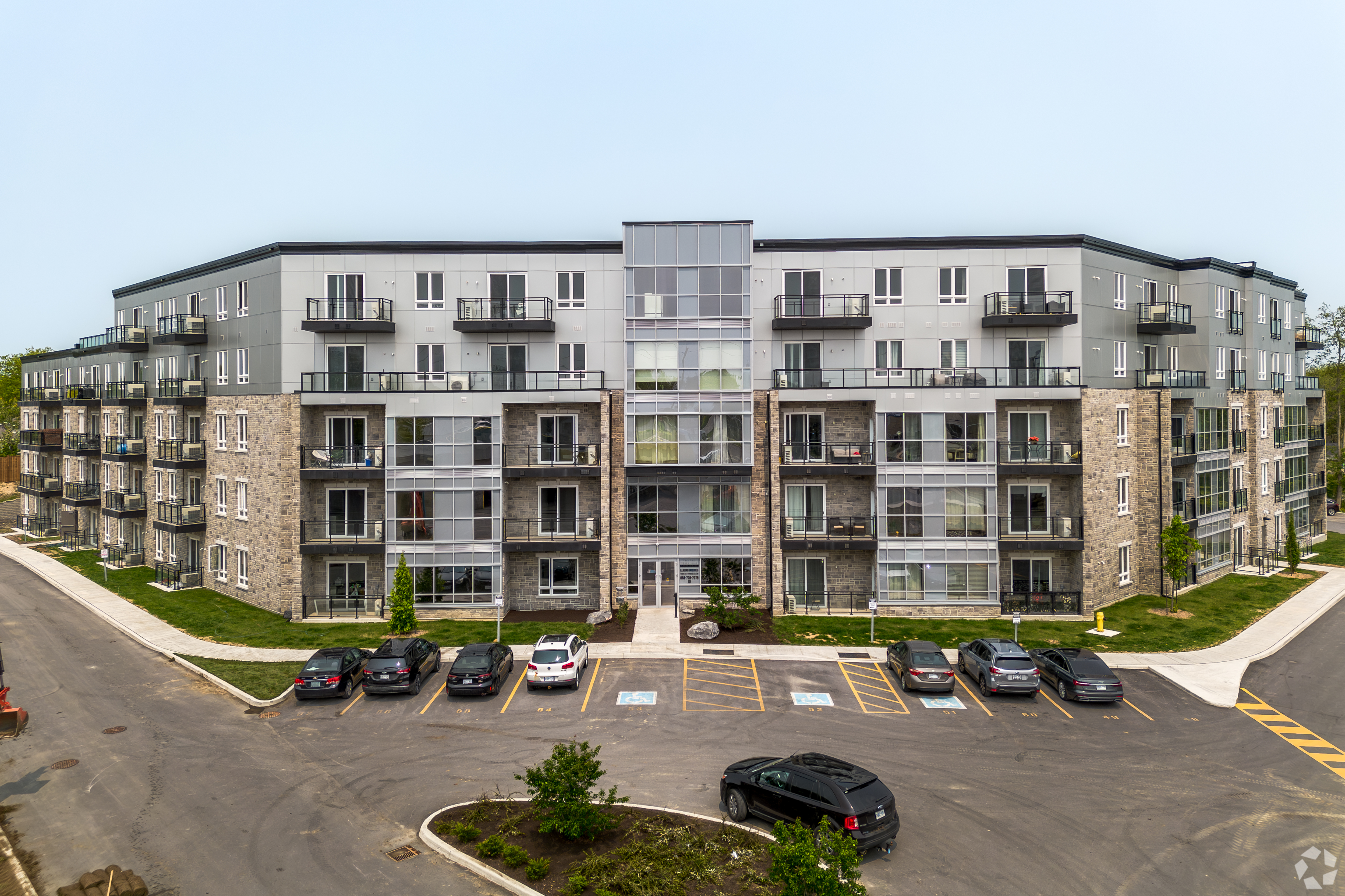 A new apartment building with a mix of stone and siding on the facade. 