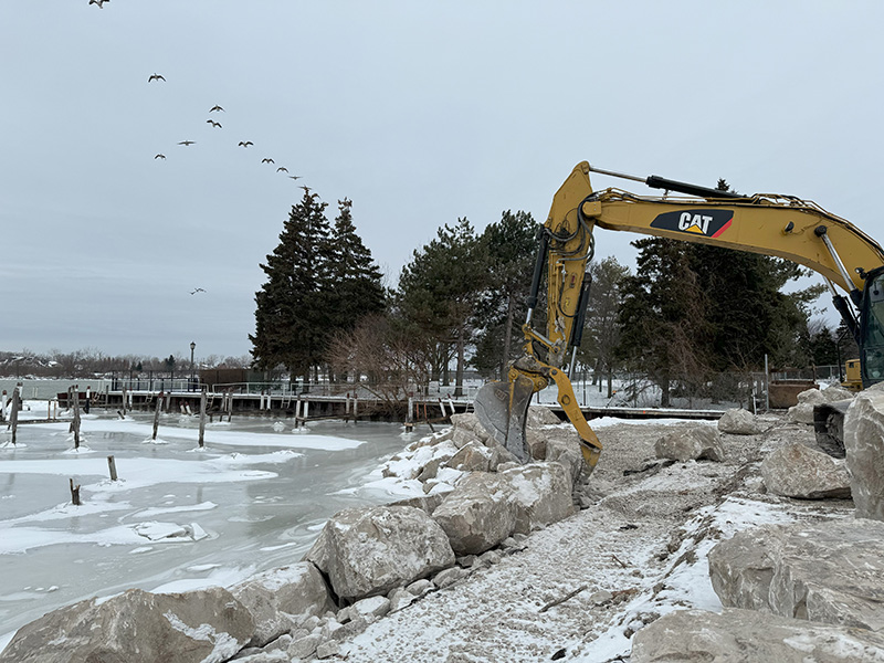 backhoe placing armour stone