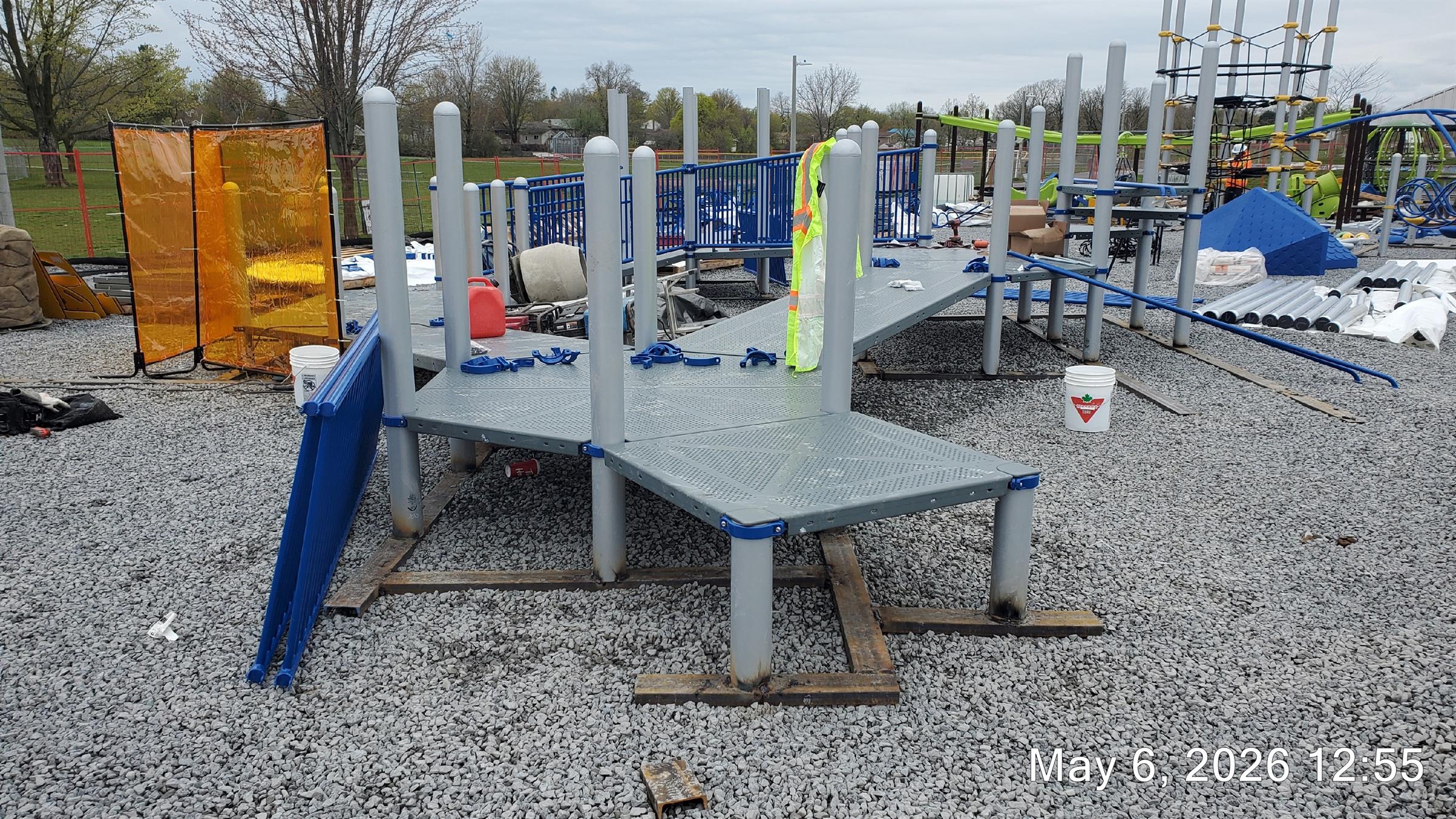 the Jumpstart Inclusive Playground under construction, with platforms and railings being built. A climbing net in the background