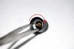 Using forceps to tighten tailcap retaining ring