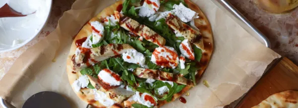 Pain plat au poulet Dijon grillé, roquette et fromage de chèvre