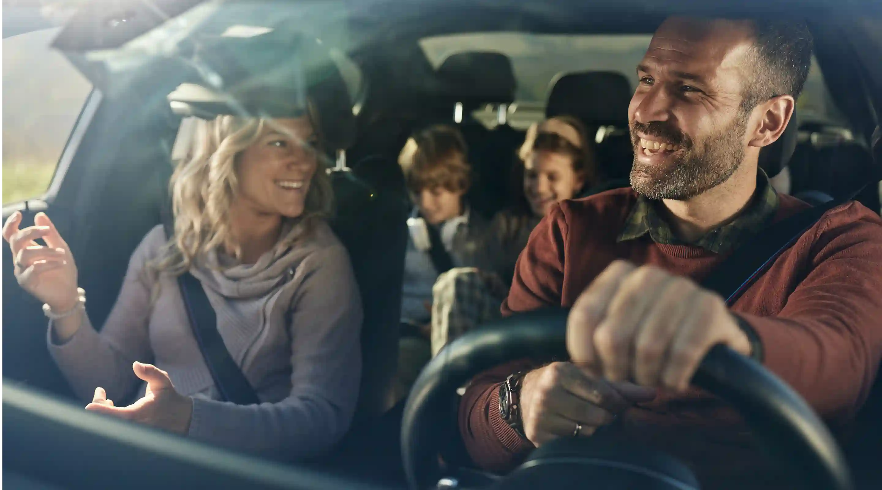 Man driving a car with his family