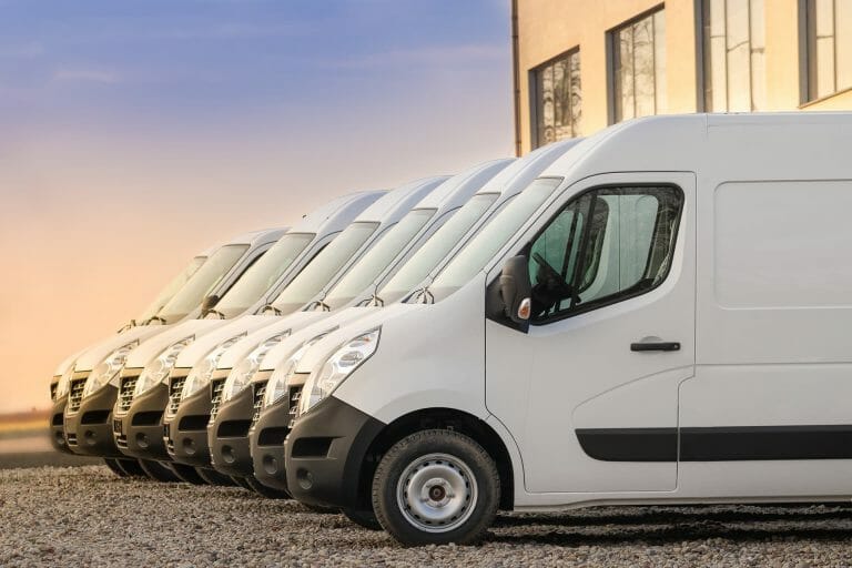 White vans lined up in a lot