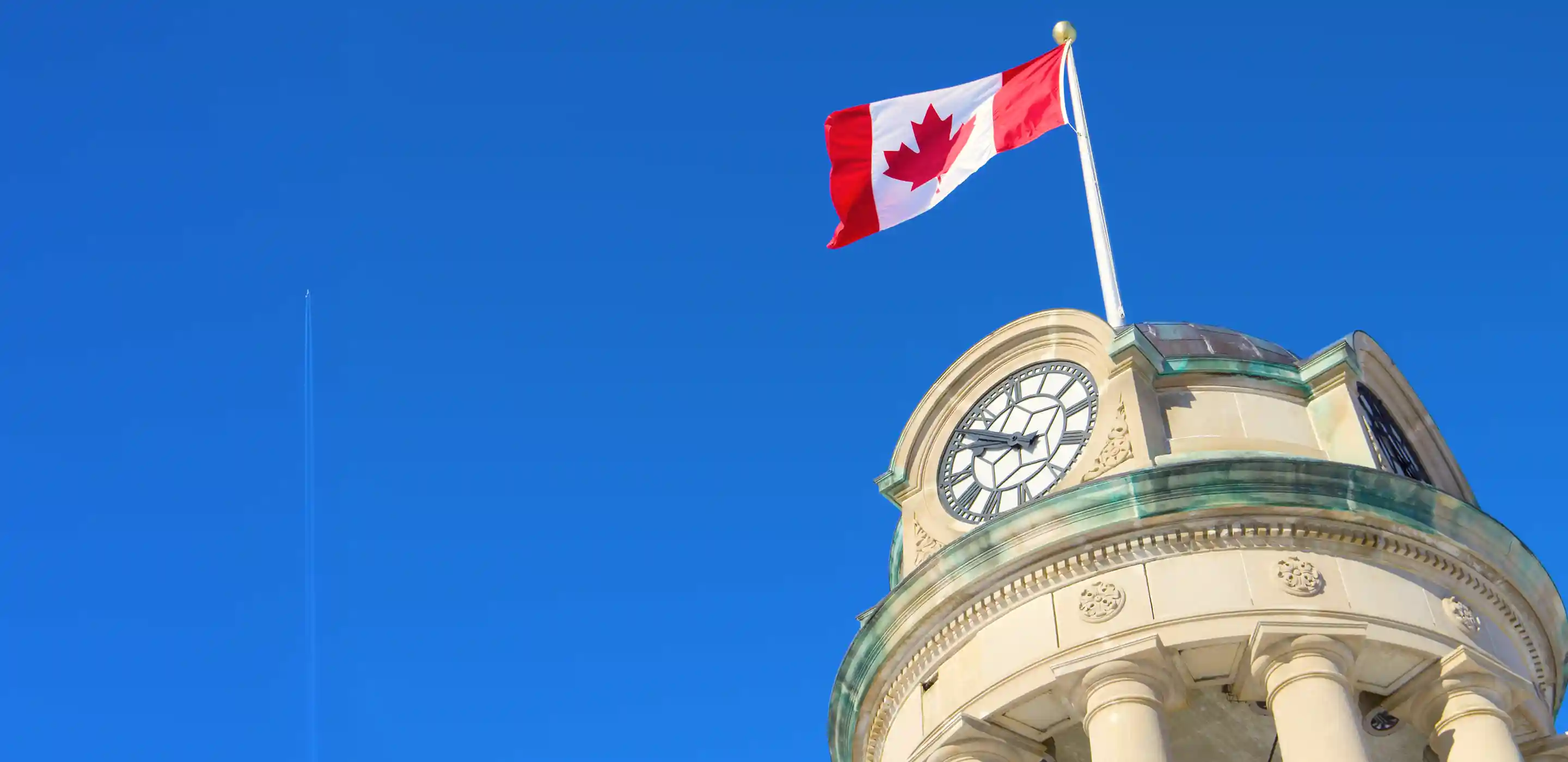 A Canadian flag against a blue sky in Waterloo Ontario