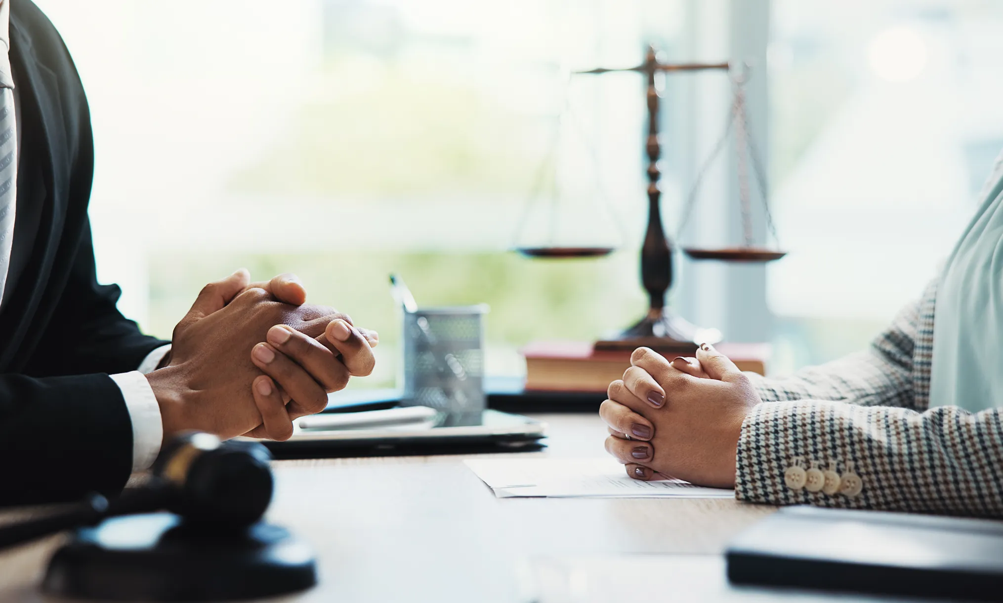 Hands folded on a desk