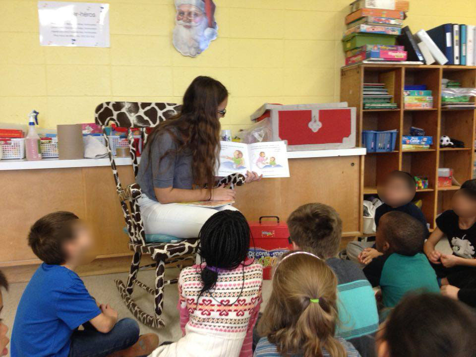Une élève fait la lecture et des jeux avec des plus jeunes