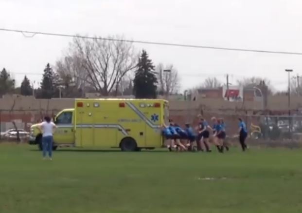 Des joueuses de rugby poussent une ambulance