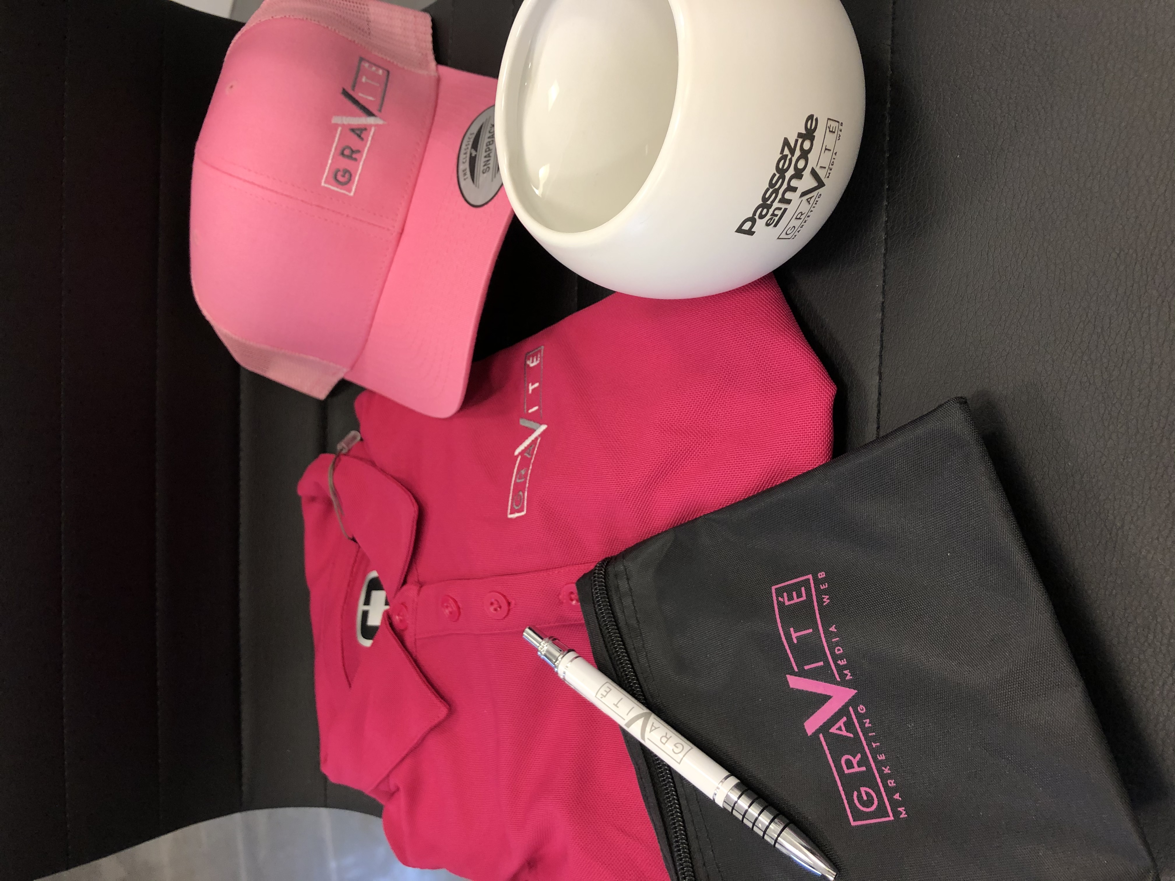 TERMINÉE – Enchère no 16 : un ensemble d&rsquo;items, dont un polo de golf fushia, à l&rsquo;effigie de Gravité Média