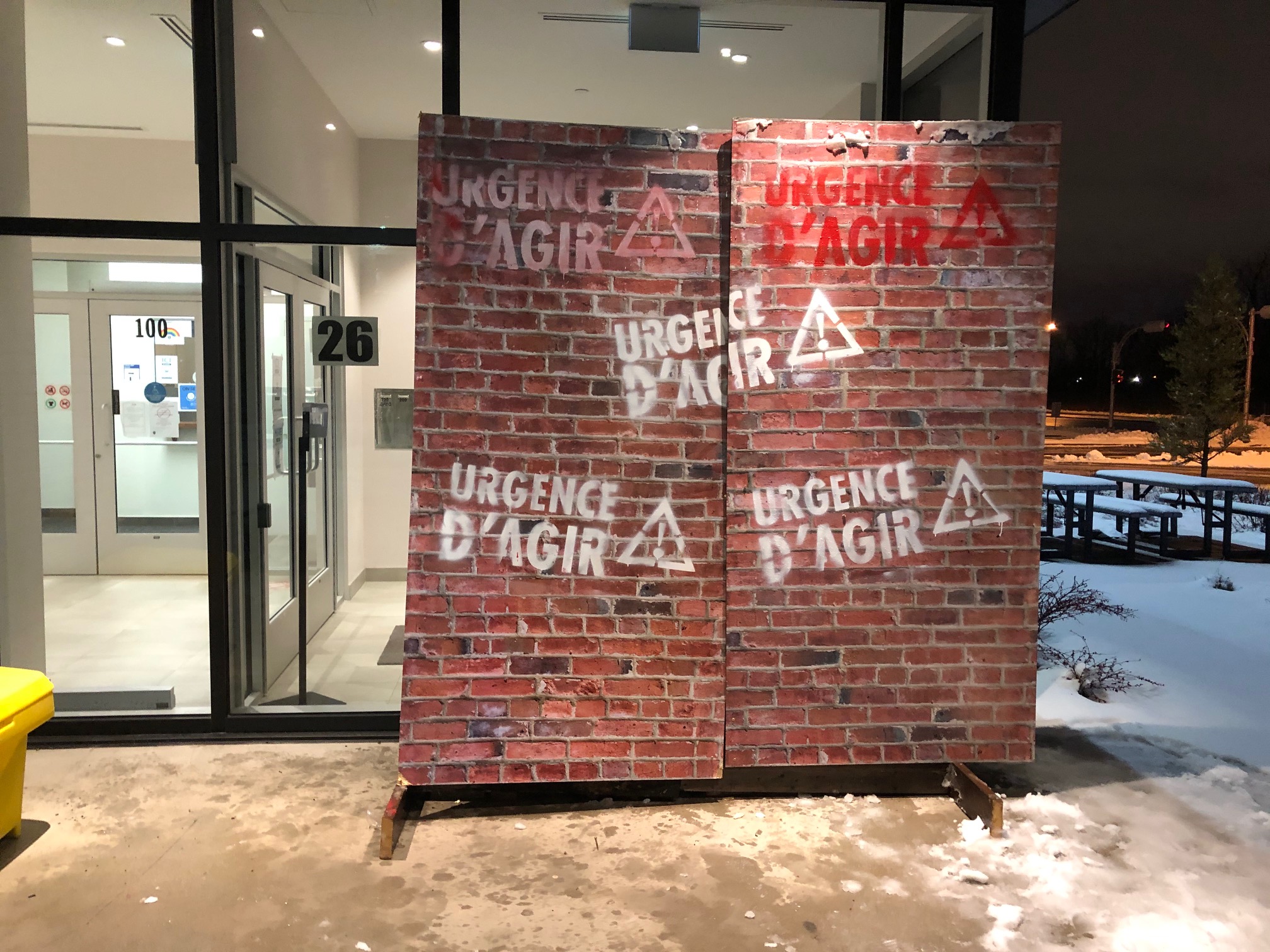 Des travailleurs de la santé érigent un mur de briques devant le bureau de Dubé à La Prairie