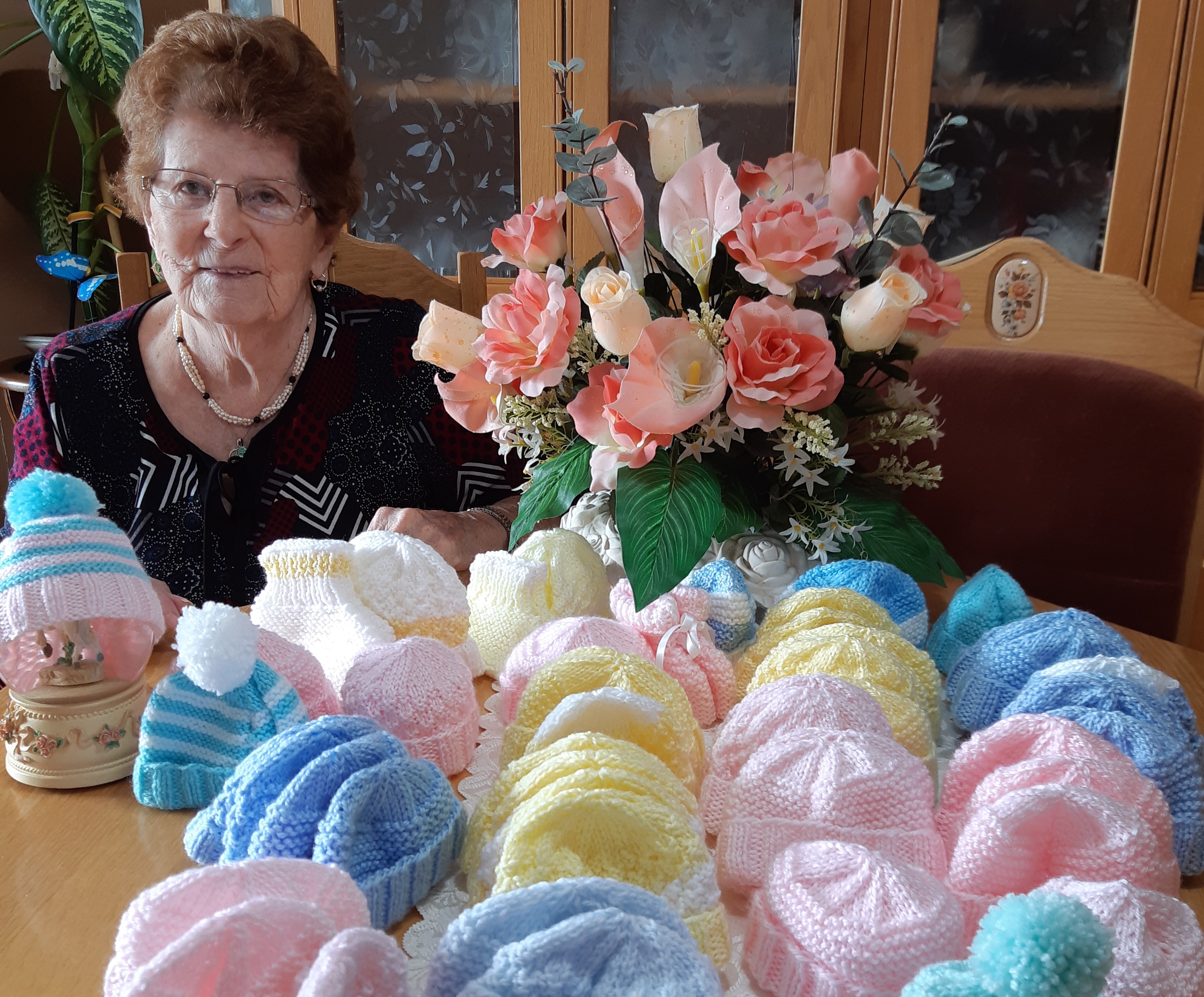 Une bénévole garde la tête des nouveau-nés au chaud