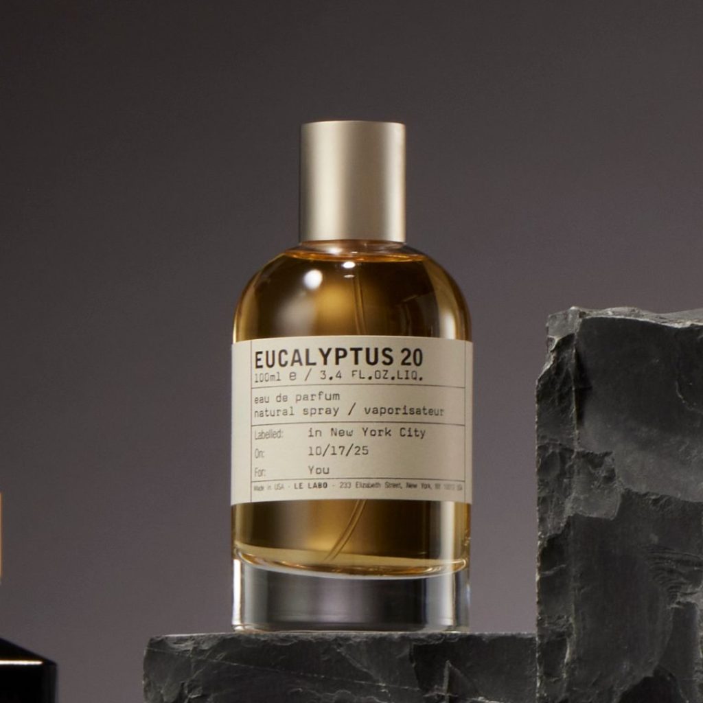 Transparent perfume bottle with dark yellow liquid and cream Le Labo label.