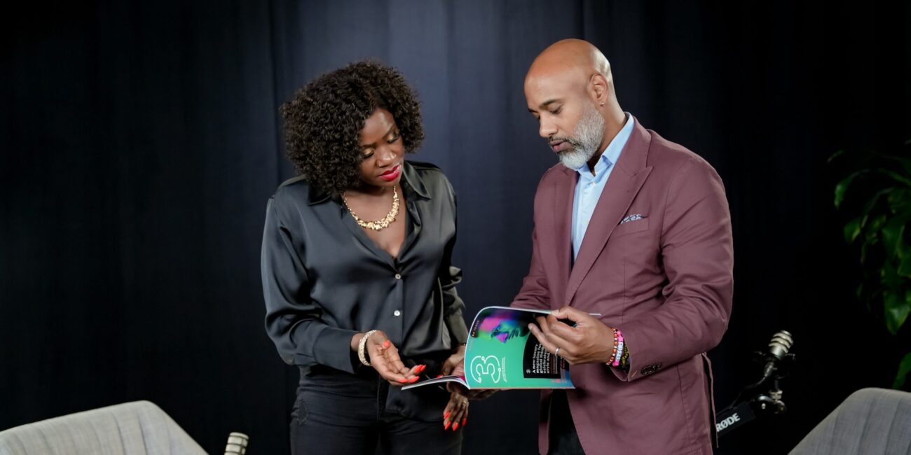 Neha Khera and Daniel Bernhard discussing leadership and cultural identity while reviewing a magazine related to the 'Third Culture Leaders' podcast series.