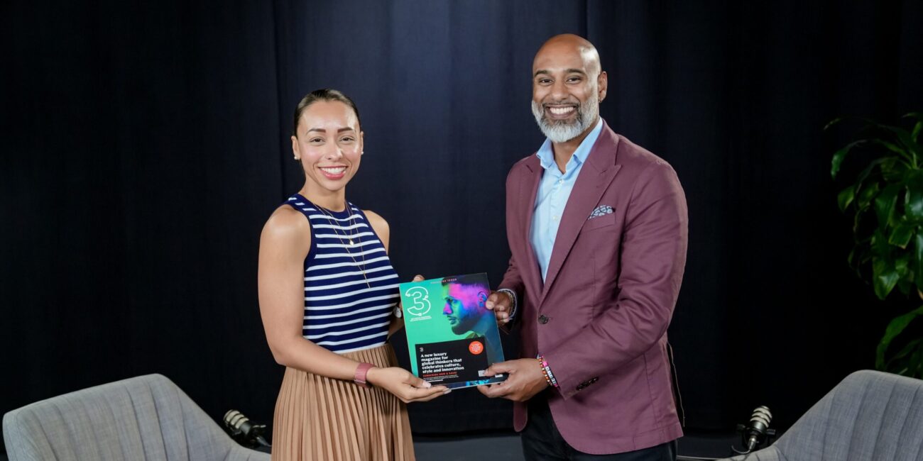 Dr. Dima Jamali and a podcast host holding a magazine featuring discussions on leadership and culture, set against a dark background.