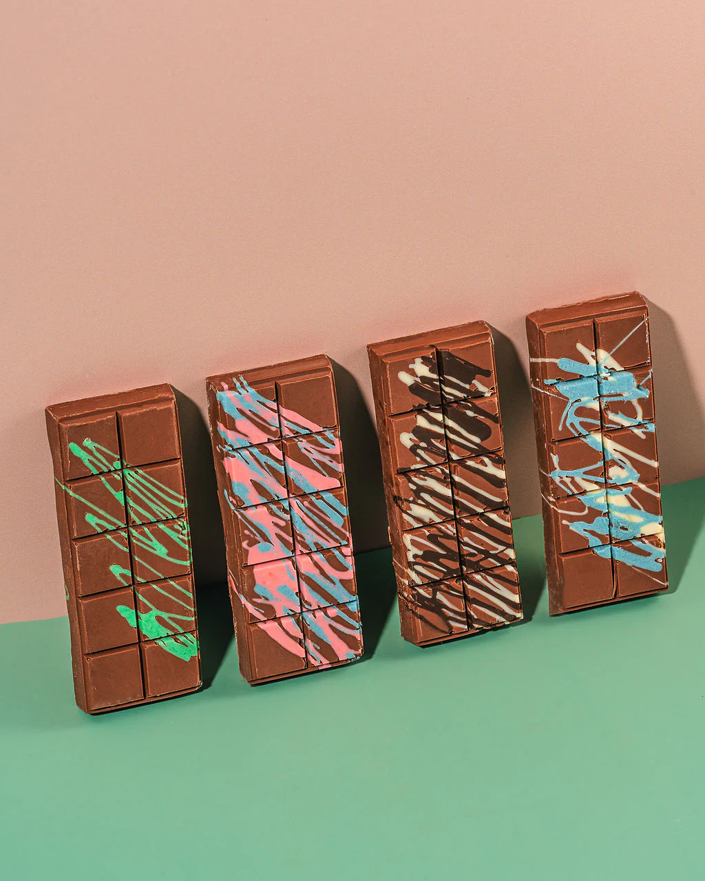 Colorful chocolate bars with artistic designs, showcasing a variety of vibrant patterns, on a pastel background, representing Middle Eastern confectionery trends.