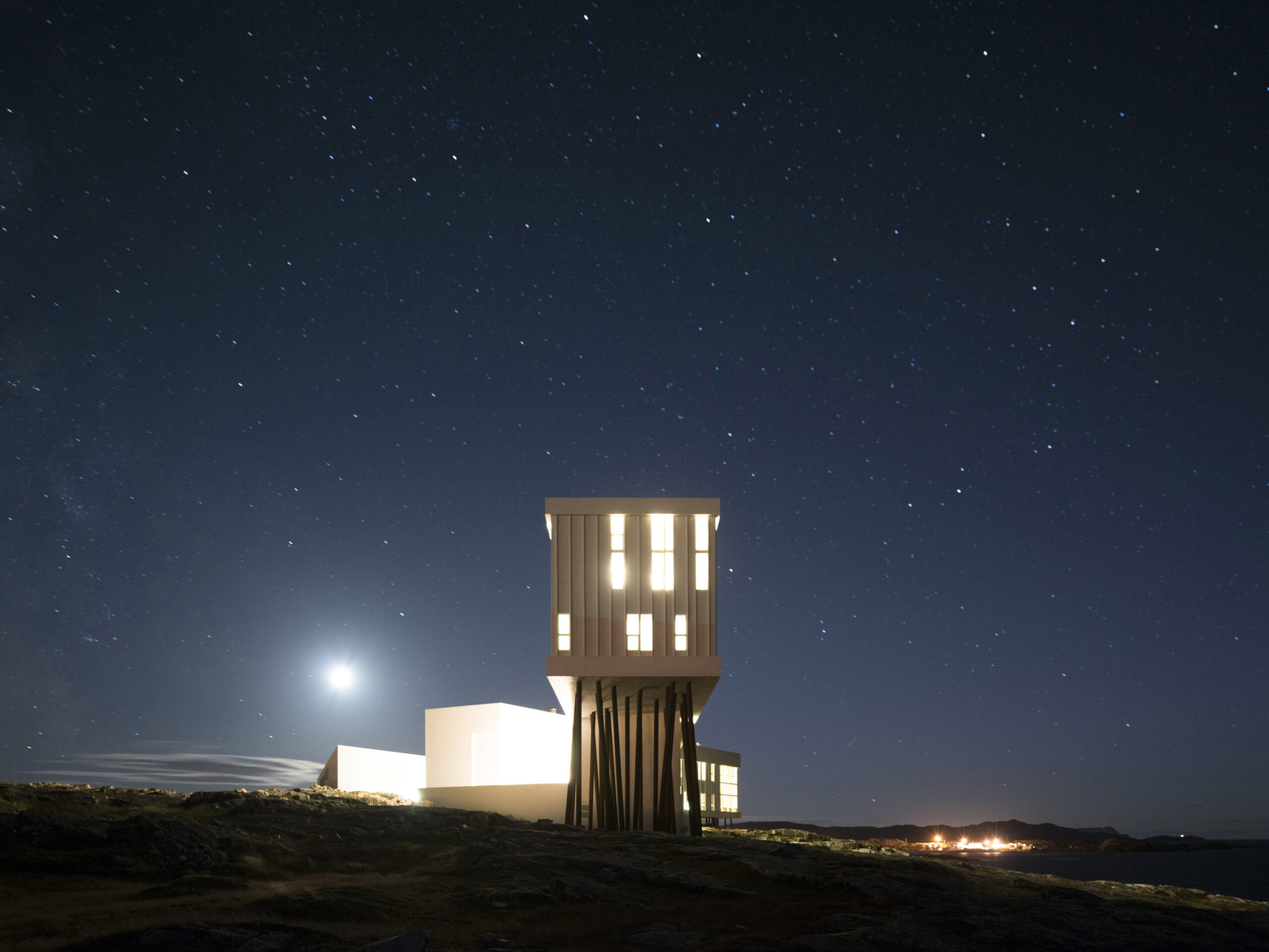 Modern architectural structure on stilts against a starry night sky, highlighting the theme of noctourism in travel experiences.