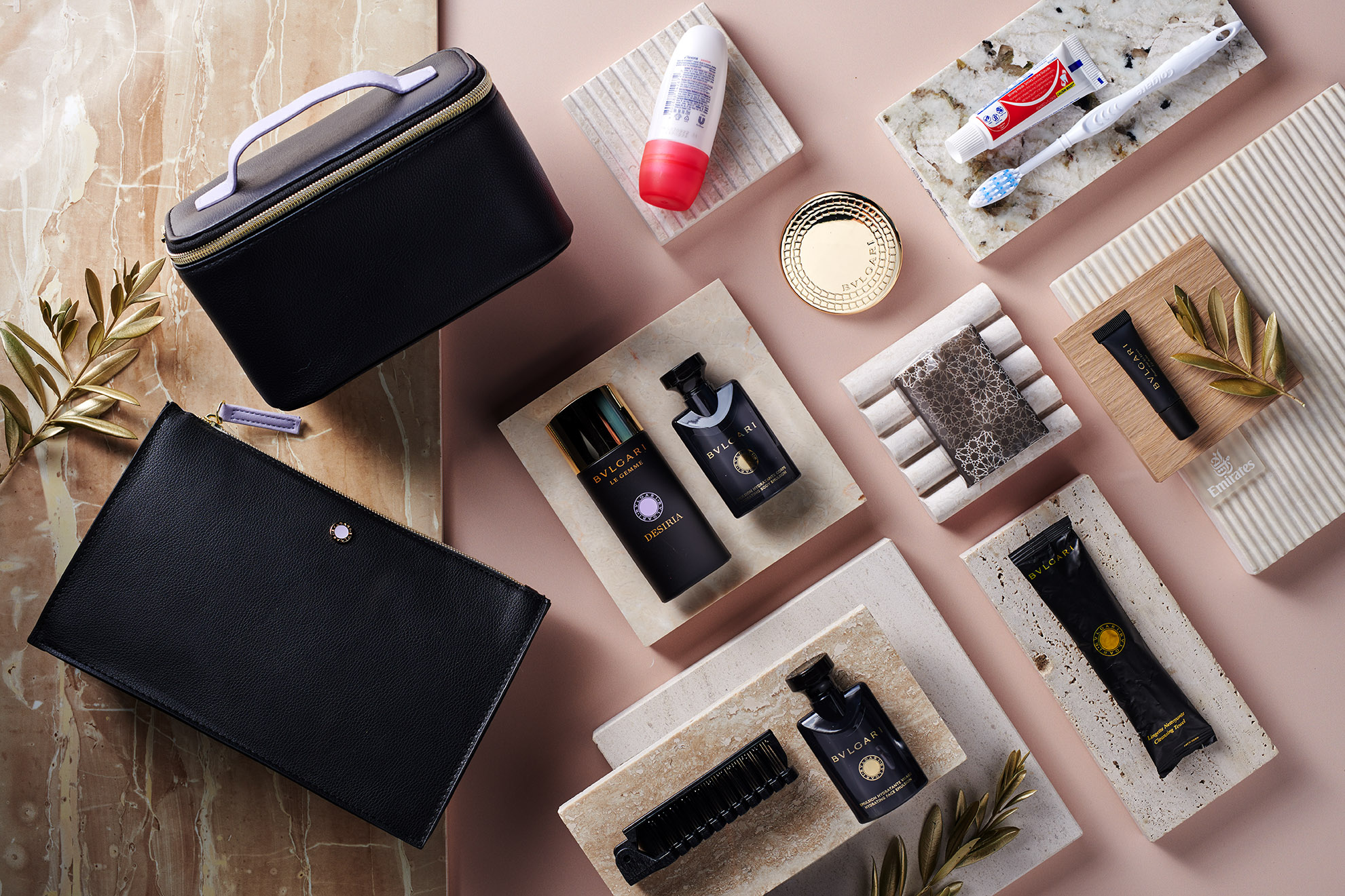 Luxury Emirates first-class amenity kit featuring Bulgari toiletries, a black travel case, toothbrush, toothpaste, and grooming items on a marble surface, reflecting high-end travel experiences.