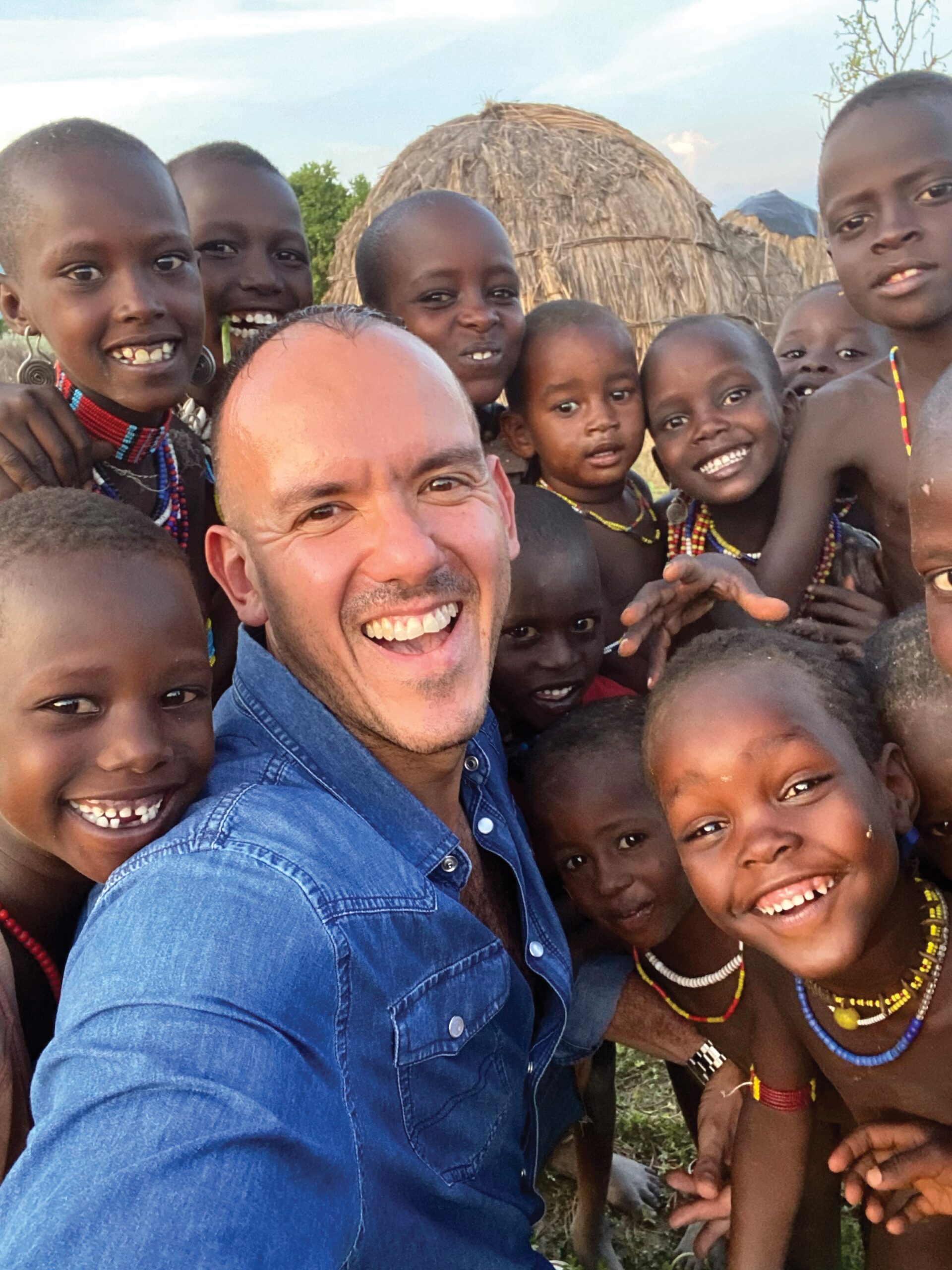 Paul Leone takes a selfie with children around him.