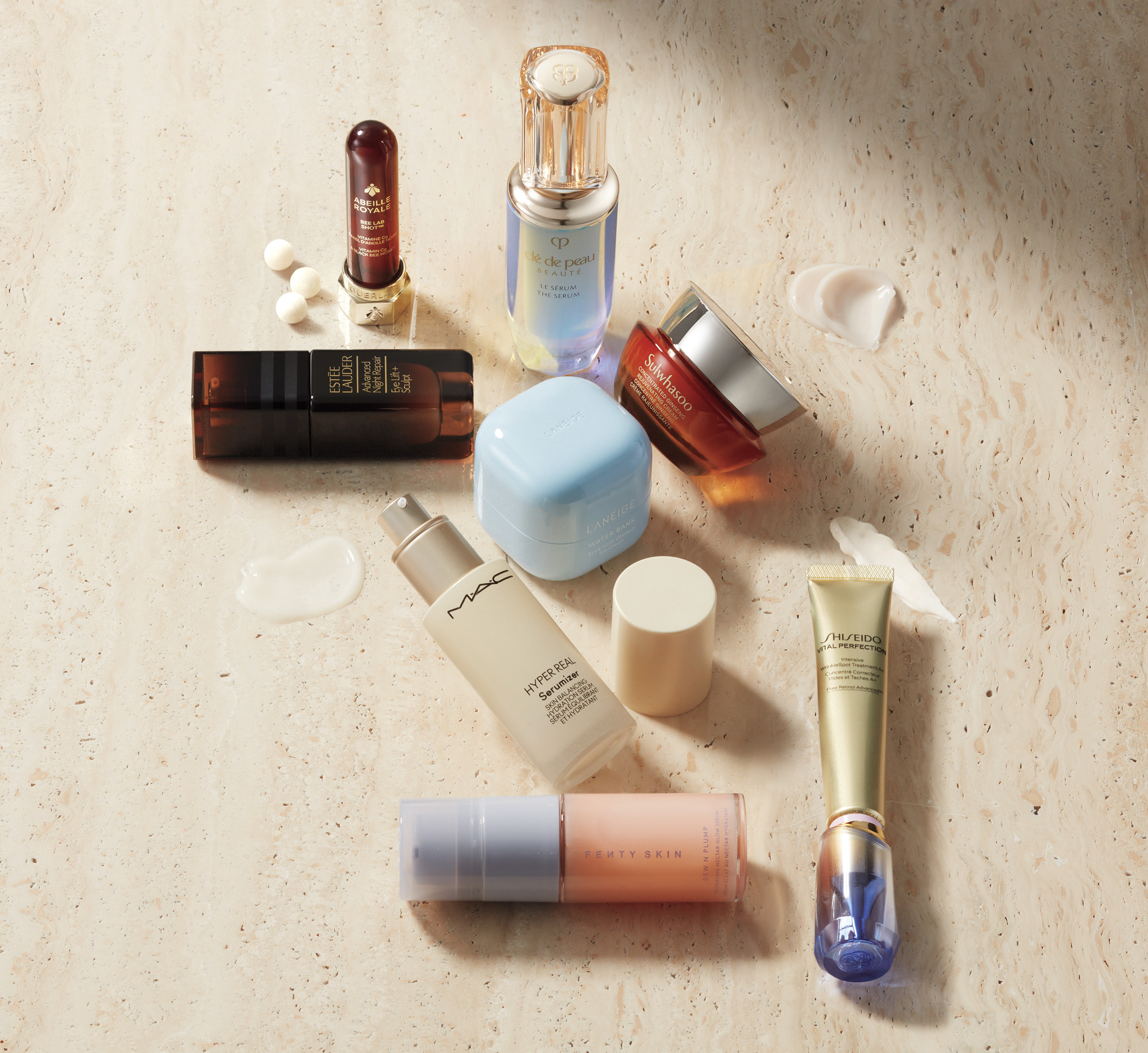 Assortment of premium skincare products including serums and moisturizers on a textured surface, highlighting key ingredients for hydrating, brightening, and anti-aging benefits.