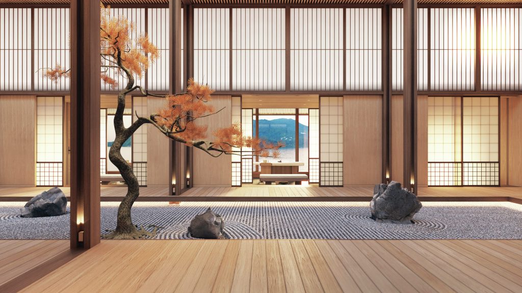 A meditation room with light wood walls and floors. There is a tree in the centre of the room and windows that show the view at sea.