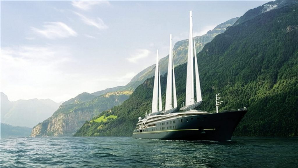 Dark green yacht sails across the water with lush greenery in the background. 