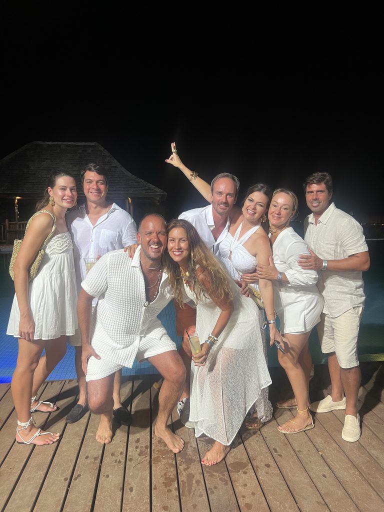 Paulo Leone and his family pose for a photo, all wearing white.
