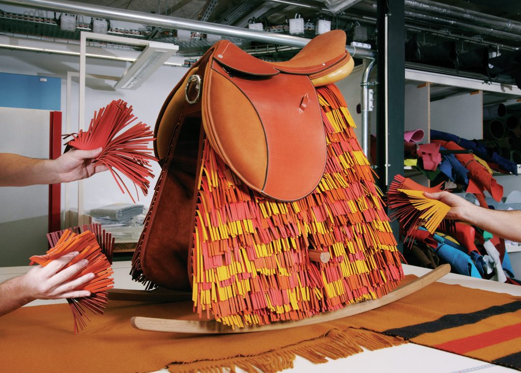 Saddle terracotta coloured fringe bag with yellow details.