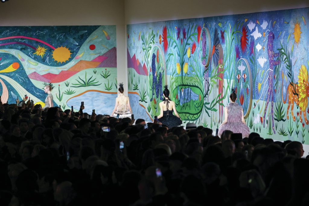 Fashion show with painted floral backdrop. 