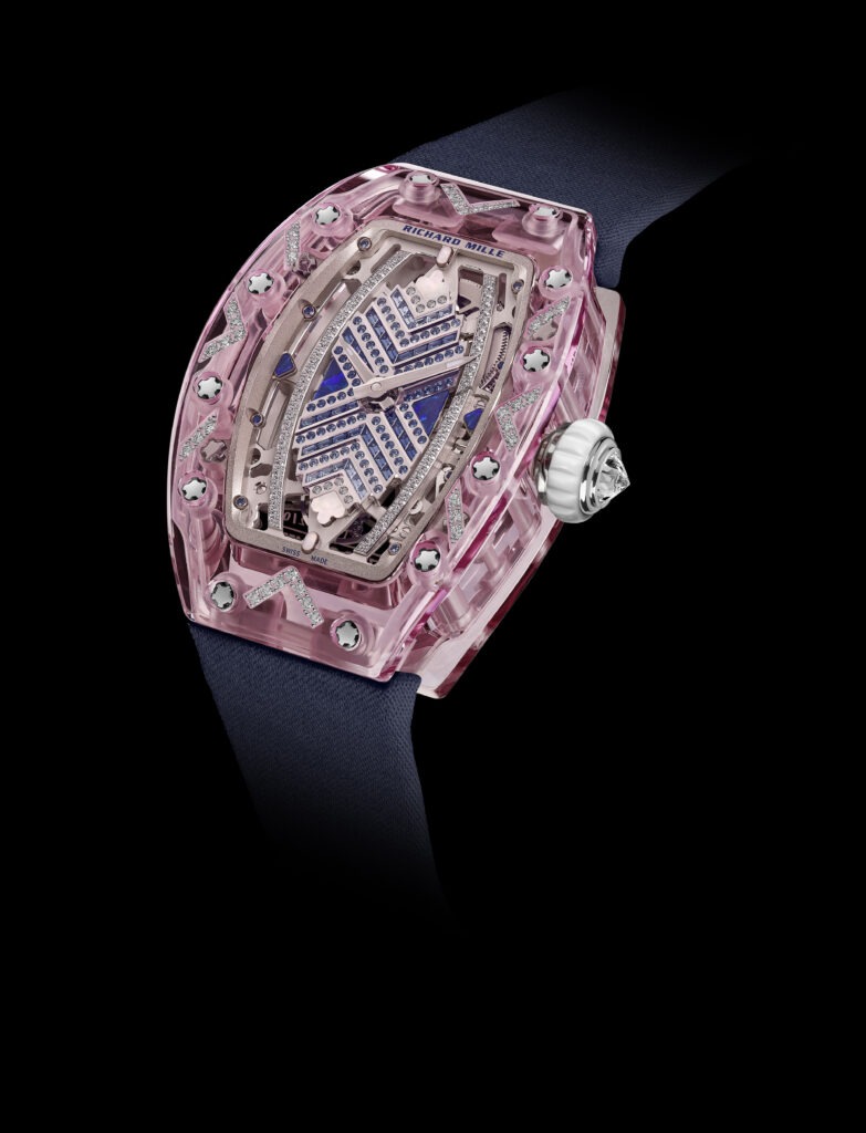 Richard Mille RM 07-02 Sapphire watch featuring a pink sapphire case, intricate diamond detailing, and a blue dial, set against a dark background, highlighting luxury and craftsmanship in the pre-owned luxury watch market.