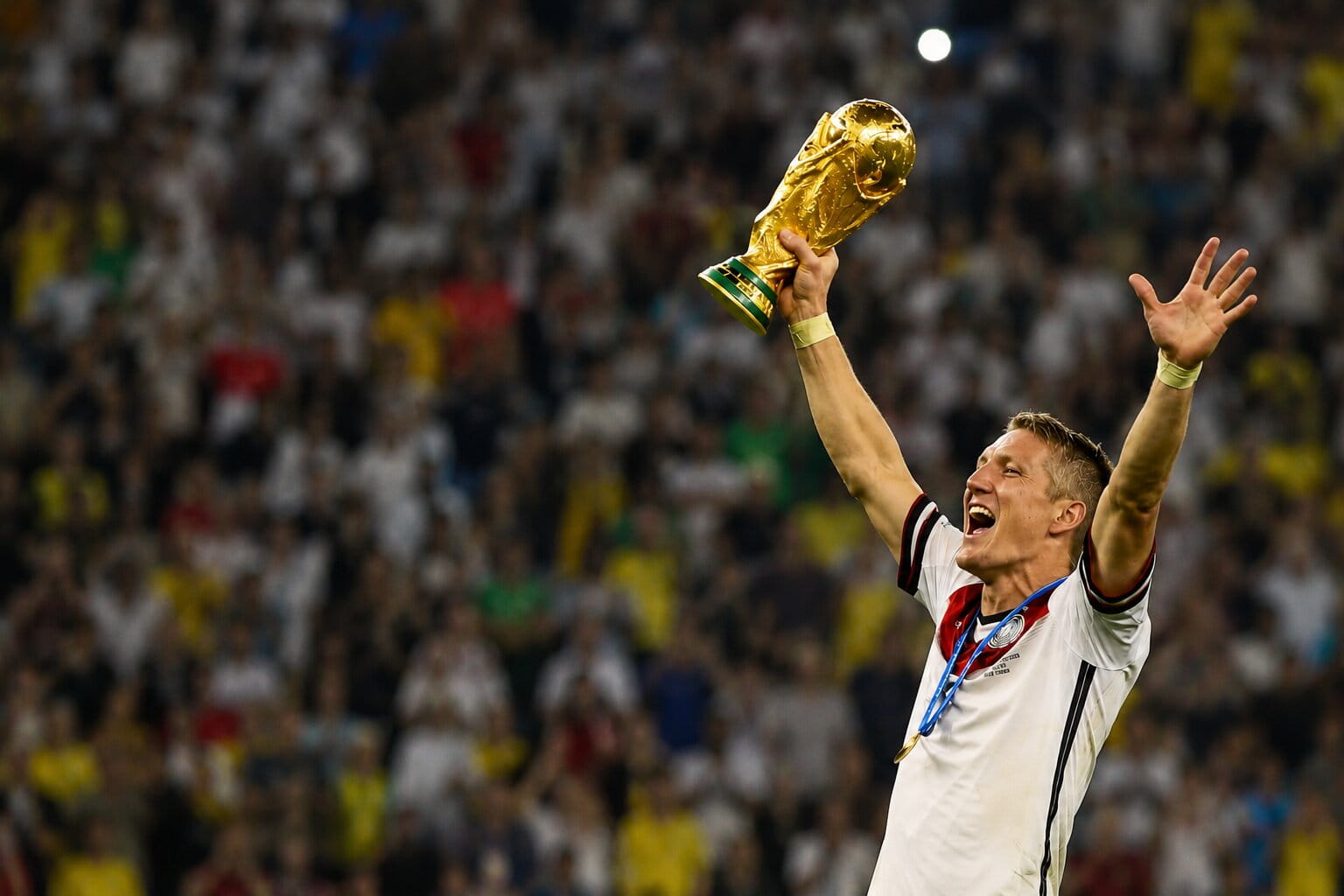 Football player holding the FIFA World Cup trophy during a stadium celebration