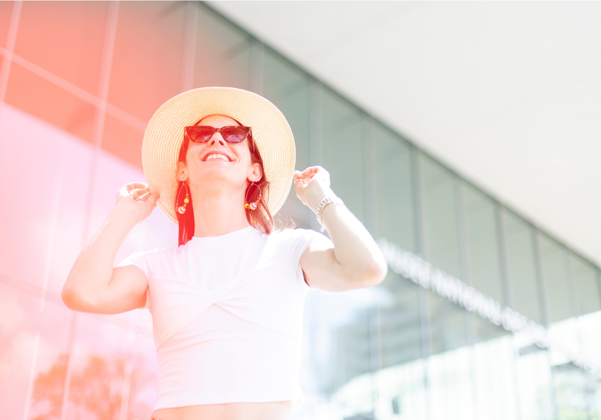 Visiteuse avec chapeau et lunettes de soleil devant le pavillon Pierre Lassonde