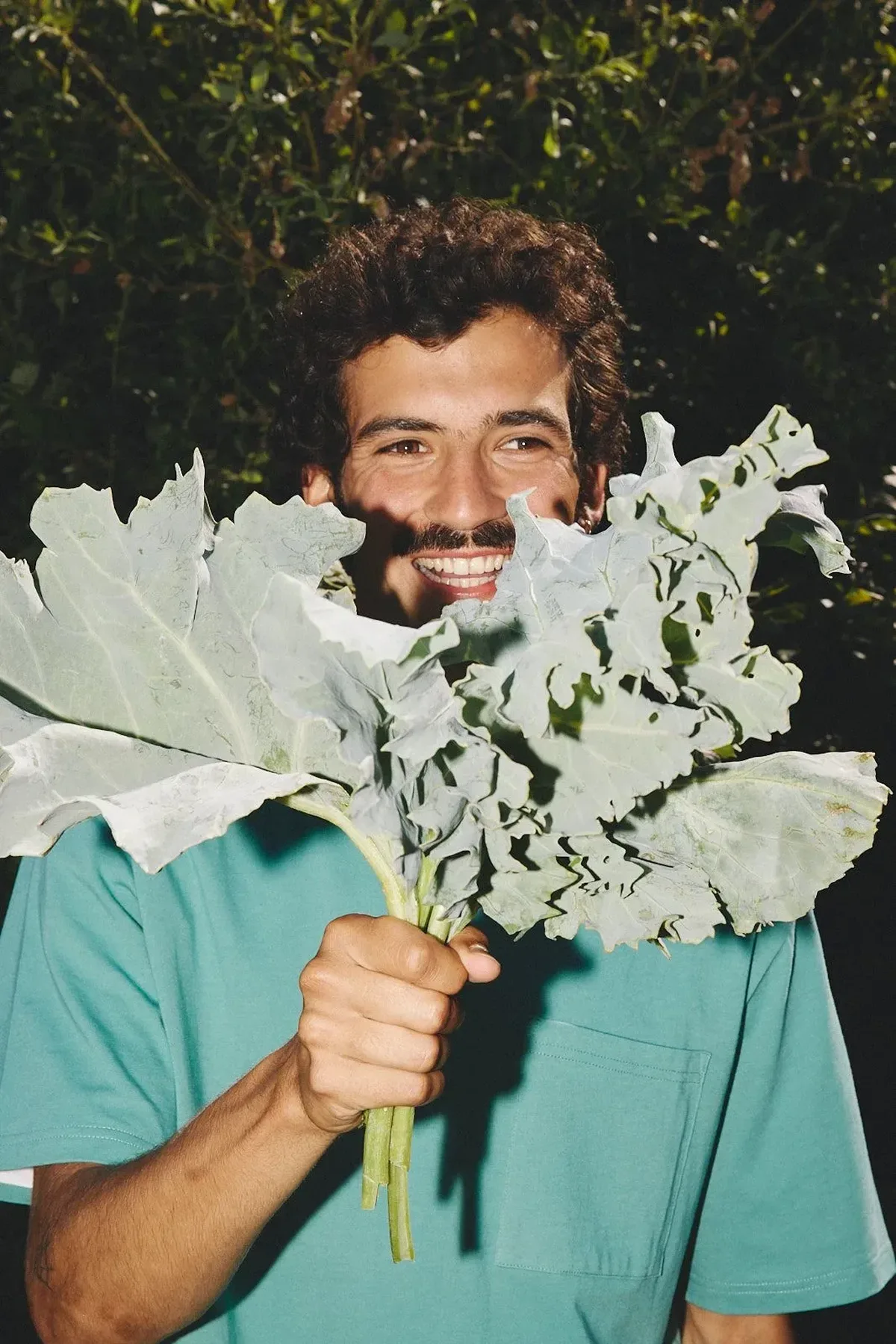 Man holding a bouquet of kale