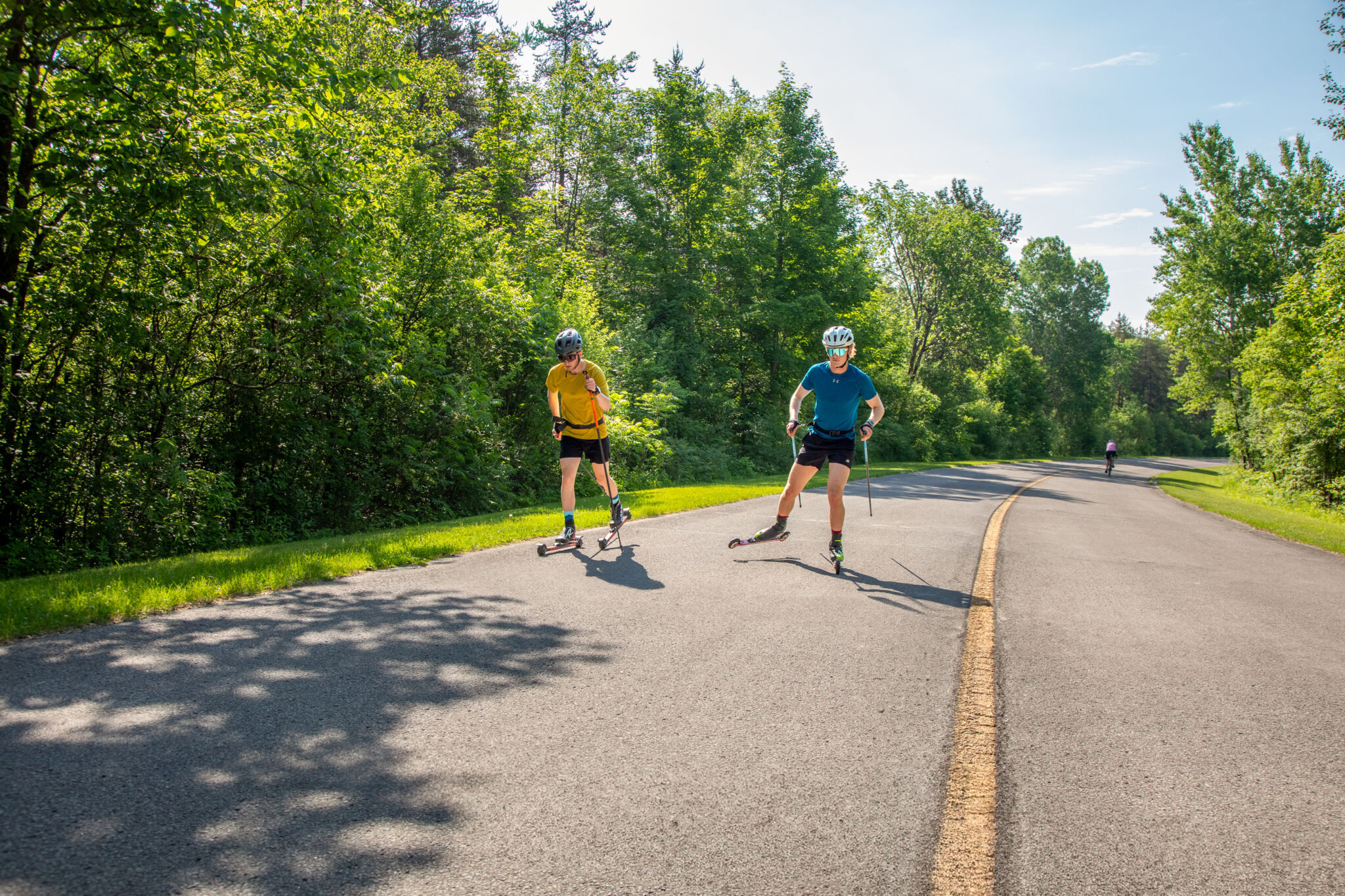 Deux personne en ski à roulettes sur la promenade du parc de la Gatineau.