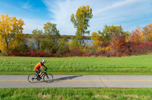 Cyclist on the multi-use pathway along the south shore of the Ottawa River, in the fall