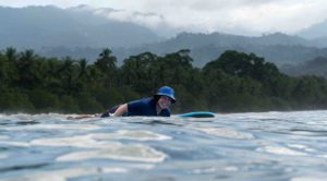 Paddling out to surf at Playa Uvita