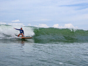 Surfing a breaking wave in Uvita, Costa Rica