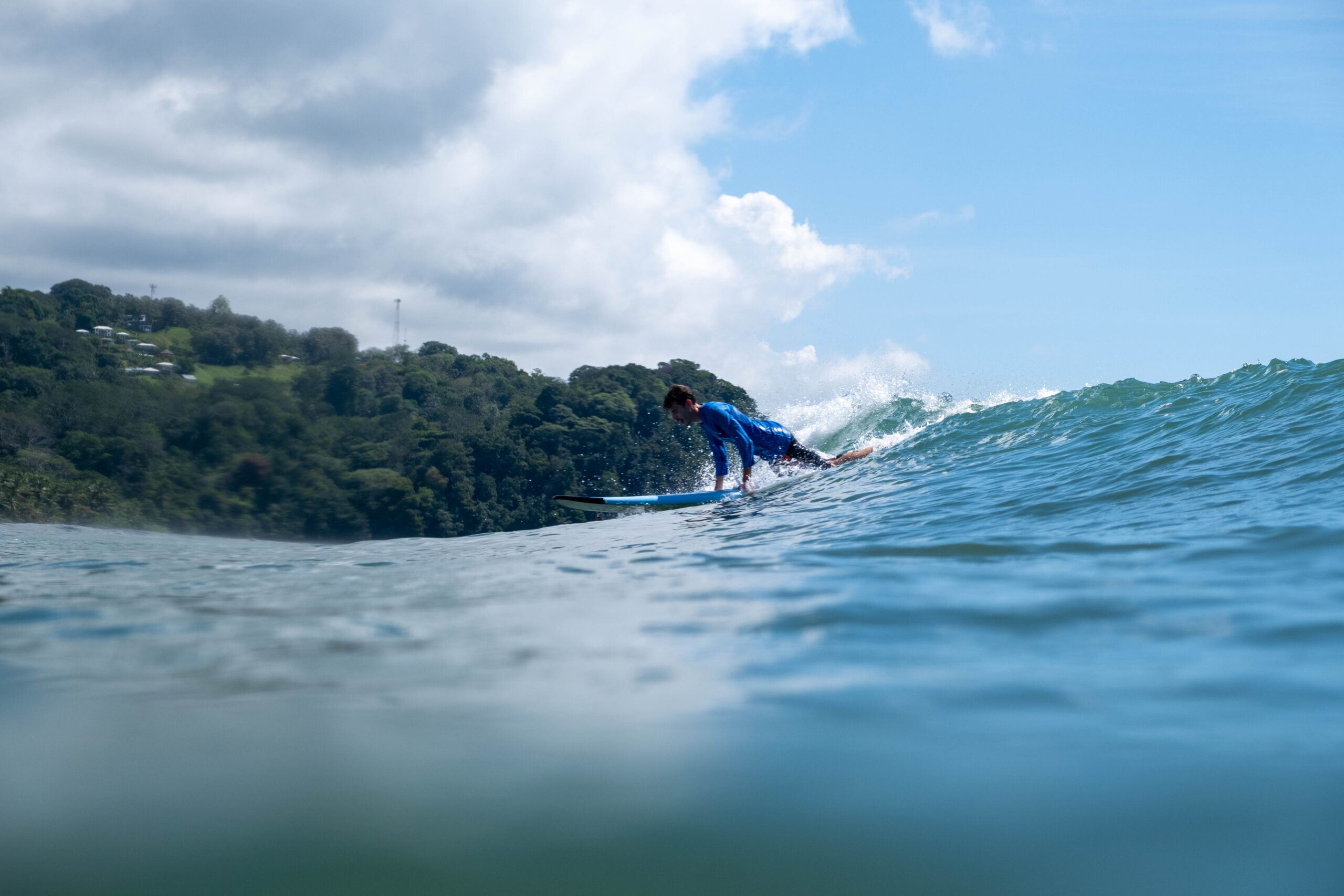 Popping up on a blue-green wave in Uvita, Osa, Costa RIca