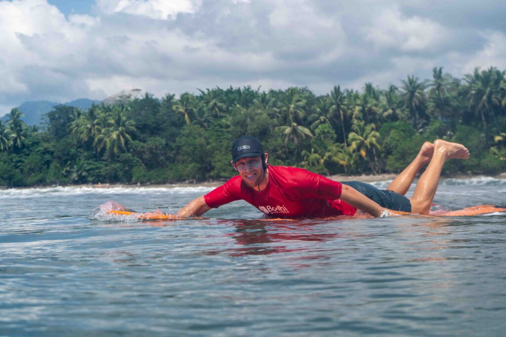 Paddling out to surf in the Marino Ballena National Park in Uvita, Osa, Costa Rica