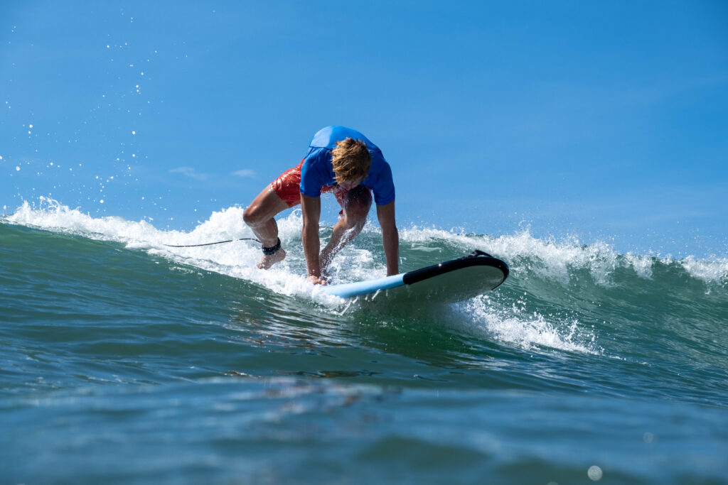 Popping up on a blue-green wave in Uvita, Osa, Costa Rica
