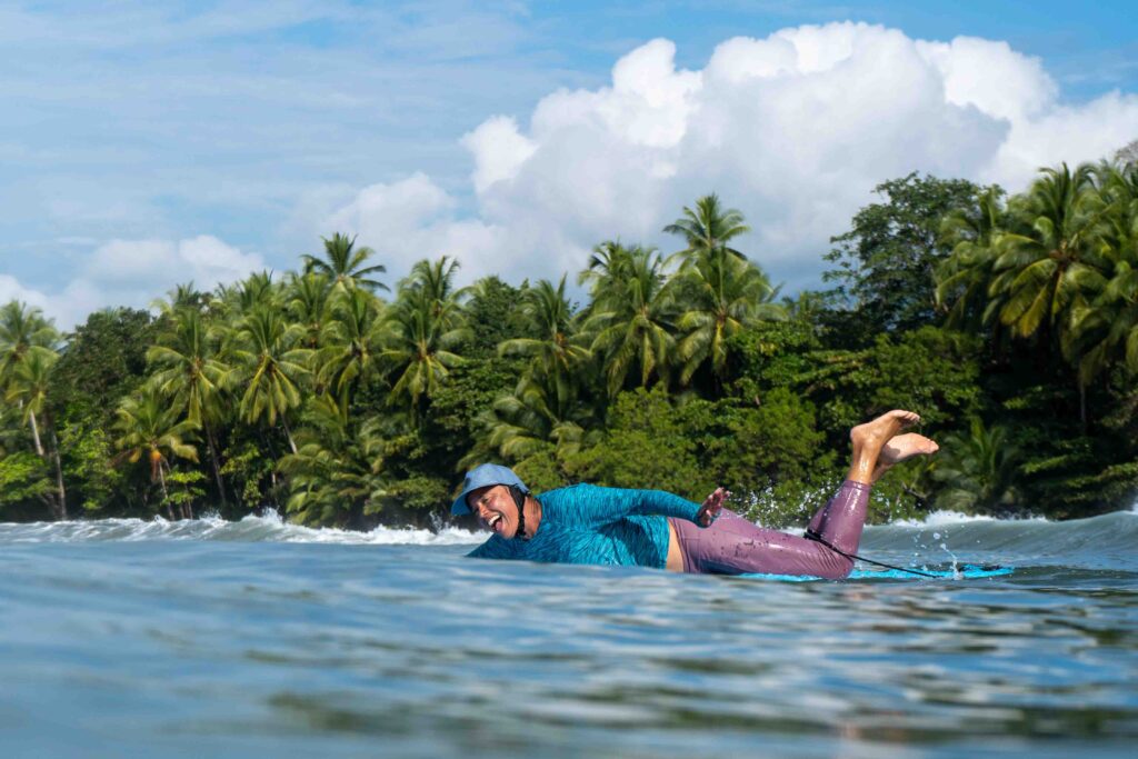 Paddling out to surf in the Marino Ballena National Park in Uvita, Osa, Costa Rica
