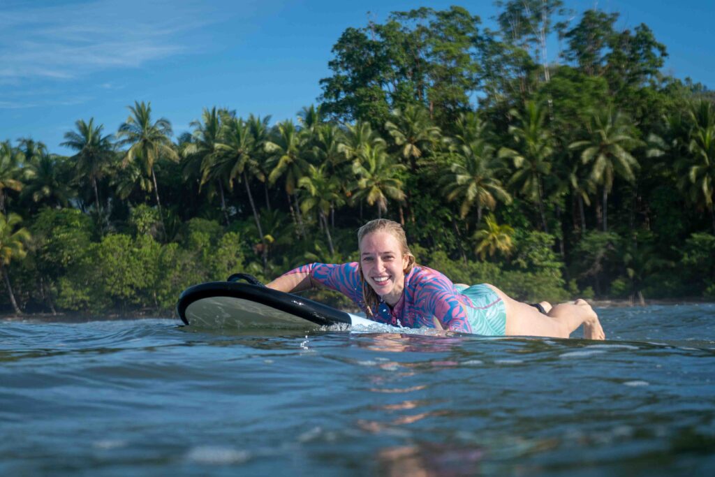 Paddling out to surf in the Marino Ballena National Park in Uvita, Osa, Costa Rica